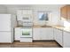 Well-lit kitchen featuring white appliances and cabinetry with a window view at 17990 E Cornell Dr, Aurora, CO 80013