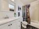 Bright bathroom features white vanity, mirror, and shower with decorative curtain at 4904 E 125Th Ave, Thornton, CO 80241