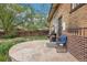 Brick home backyard with stone patio, BBQ grill, and outdoor seating under mature trees at 925 S University Blvd, Denver, CO 80209