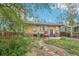 This backyard shows a brick house with a grill, a stone pathway, and landscaping at 925 S University Blvd, Denver, CO 80209