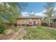 Brick home exterior with stone patio, BBQ grill, green lawn, and garden path in a spacious backyard at 925 S University Blvd, Denver, CO 80209