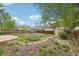 A large backyard showing the grassy area, stone patio, stone path, landscaping, and wooden fence at 925 S University Blvd, Denver, CO 80209