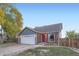 Gray and brick ranch home with a two-car garage and red front door at 7814 Club Crest Dr, Arvada, CO 80005