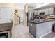 Open kitchen layout with gray cabinets, stainless steel appliances, and access to the staircase at 2143 Coronado N Pkwy # C, Denver, CO 80229