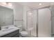 Clean bathroom with a glass enclosed shower, white tiling and modern fixtures at 6027 N Netherland Ct, Aurora, CO 80019