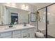 Modern bathroom featuring double sinks, a shower with glass doors, and stylish black fixtures at 6027 N Netherland Ct, Aurora, CO 80019
