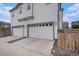 Exterior shot of townhome garages with white doors and gray trim at 6027 N Netherland Ct, Aurora, CO 80019