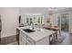 Open concept kitchen with island seating flows into the dining area, featuring modern finishes and ample light at 6027 N Netherland Ct, Aurora, CO 80019