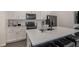 Contemporary kitchen boasting a quartz countertop island with seating and black appliances at 6027 N Netherland Ct, Aurora, CO 80019