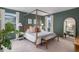 Serene main bedroom showcasing a four-poster bed, modern decor, and abundant natural light from large windows at 6027 N Netherland Ct, Aurora, CO 80019