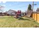 A large backyard with a playset, grass, and a wooden fence at 479 S Kendall St, Lakewood, CO 80226