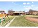 Large backyard featuring a swing set, a dirt patch, and green grass at 479 S Kendall St, Lakewood, CO 80226