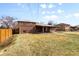 Spacious backyard featuring a brick house, green grass, and a wooden fence at 479 S Kendall St, Lakewood, CO 80226