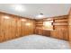 A carpeted basement room with wood paneling and built in cabinets and storage space at 479 S Kendall St, Lakewood, CO 80226