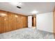 A finished basement space with wood paneling, carpet, and a doorway leading to a closet at 479 S Kendall St, Lakewood, CO 80226