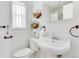 Clean bathroom features a pedestal sink, decorative plants, and a window at 479 S Kendall St, Lakewood, CO 80226