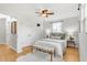 Bright bedroom features a woven bench and a decorative ceiling fan with hardwood floors at 479 S Kendall St, Lakewood, CO 80226