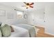 Bright bedroom featuring a decorative ceiling fan, two windows, and hardwood floors at 479 S Kendall St, Lakewood, CO 80226