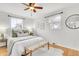 Cozy bedroom featuring hardwood floors, a ceiling fan, and two large windows at 479 S Kendall St, Lakewood, CO 80226