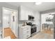 Well-lit kitchen with white cabinets, quartz countertops, and modern appliances at 479 S Kendall St, Lakewood, CO 80226