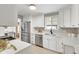 Bright kitchen features white cabinets, stainless steel appliances, and quartz countertops at 479 S Kendall St, Lakewood, CO 80226