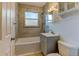 This bathroom features a tub, shower, tiled walls, and a vanity with a sink and mirror at 4078 Ames St, Wheat Ridge, CO 80212