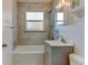 Updated bathroom featuring modern vanity, tub and shower combination, and tiled walls at 4078 Ames St, Wheat Ridge, CO 80212