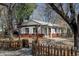 Home exterior featuring a garden, red brick accents, stone landscaping, and wooden privacy fence at 4078 Ames St, Wheat Ridge, CO 80212
