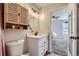 Well-lit bathroom with a modern vanity, round mirror, and a view into the adjacent bedroom at 6333 Zang Ct # E, Arvada, CO 80004