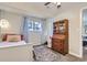 Bright bedroom featuring carpet, side table, window, and a wooden storage cabinet at 6333 Zang Ct # E, Arvada, CO 80004