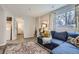 Bright living area featuring a blue sofa, patterned rug, and a view of the backyard at 6333 Zang Ct # E, Arvada, CO 80004
