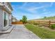 Backyard featuring a concrete patio, green grass, partial fence, and a hill behind at 154 Back Nine Dr, Castle Pines, CO 80108