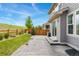 Backyard view showing a concrete patio, wood fence, and a grassy hillside at 154 Back Nine Dr, Castle Pines, CO 80108