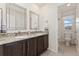 Bathroom showcasing dual sinks with granite counters, framed mirrors, and a nearby enclosed toilet and shower at 154 Back Nine Dr, Castle Pines, CO 80108