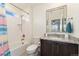Well-lit bathroom featuring granite counters, modern fixtures, framed mirror, and a shower with white tile surround at 154 Back Nine Dr, Castle Pines, CO 80108