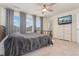 Bedroom with neutral carpet, large windows with curtains, ceiling fan, bed, and dresser with mounted television at 154 Back Nine Dr, Castle Pines, CO 80108