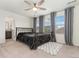 Bedroom featuring neutral carpet, a bed, ceiling fan, windows with curtains, and view to the bathroom at 154 Back Nine Dr, Castle Pines, CO 80108