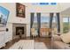 Cozy living room featuring a stone fireplace and a view of the outdoors at 154 Back Nine Dr, Castle Pines, CO 80108