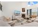 Comfortable living room with fireplace, large windows, and open access to other living spaces at 154 Back Nine Dr, Castle Pines, CO 80108