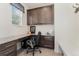 Bright home office with granite desk, custom cabinetry, and tile flooring providing an efficient workspace at 154 Back Nine Dr, Castle Pines, CO 80108