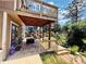 Backyard deck offering outdoor entertaining, lounge area, and dining space with stairs leading to an upper wooden balcony at 1744 Brookside Dr, Highlands Ranch, CO 80126