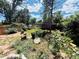 Landscaped backyard with a playhouse, garden, flowerbeds, trees, and privacy fence, perfect for Gathering fun at 1744 Brookside Dr, Highlands Ranch, CO 80126