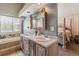 Spa-like bathroom features a soaking tub, dual vanity, chandelier, and view into the Primary bedroom at 1744 Brookside Dr, Highlands Ranch, CO 80126