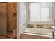 Well-appointed bathroom showcasing a tiled shower, soaking tub, and built-in shelving at 1744 Brookside Dr, Highlands Ranch, CO 80126