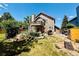 Two-story home exterior with an upper deck, lower deck, outdoor grill, landscaping, and mature trees at 1744 Brookside Dr, Highlands Ranch, CO 80126