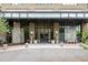 Elegant condo building entrance featuring stonework, glass doors, and manicured landscaping at 5455 Landmark Pl # 815, Greenwood Village, CO 80111