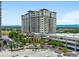 View of a high-rise condo building with balconies and commercial spaces surrounded by greenery at 5455 Landmark Pl # 815, Greenwood Village, CO 80111