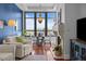 Sunlit living room featuring a fireplace, hardwood floors, a dining area and expansive city views at 5455 Landmark Pl # 815, Greenwood Village, CO 80111