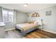 Cozy bedroom featuring wood-look floors, a window, and a decorative mountain shelf at 8555 S Fairmount Dr # 107, Denver, CO 80247