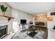 Living room with a stone fireplace and open floor plan to the dining area and kitchen at 8555 S Fairmount Dr # 107, Denver, CO 80247